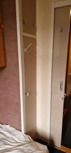 a closet with a door next to a bed at Knusse kamer om te kunnen overnachten in Rotterdam