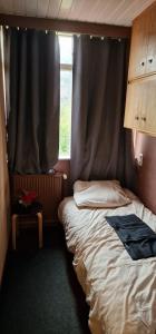 a small room with a bed and a window at Knusse kamer om te kunnen overnachten in Rotterdam