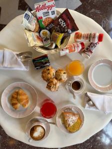 Ein weißer Teller mit Frühstücksspeisen auf einem Tisch in der Unterkunft Hotel Verdi Boutique Hotel in Parma