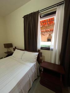 une chambre avec un lit blanc et une fenêtre dans l'établissement Chácara Vovô João, à São Paulo 110 autres photos