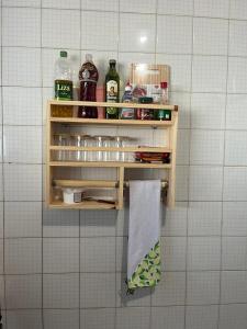 une étagère dans une salle de bain avec des flacons et une serviette dans l'établissement Chácara Vovô João, à São Paulo