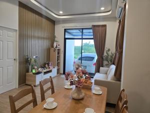 a dining room with a table and a living room with a car at Klong Loung House Airport transportation service in Pathum Thani