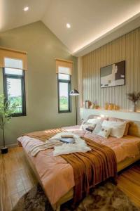a bedroom with a large bed in a room with windows at Klong Loung House Airport transportation service in Pathum Thani