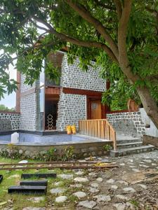 a bench in front of a building with a tree at whispering roots resort in Jim Corbett
