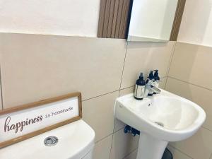 a bathroom with a white sink and a toilet at 2Bed in exquisite golf estate! in Roodepoort