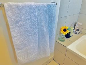 a white towel hanging in a bathroom next to a sink at 2Bed in exquisite golf estate! in Roodepoort
