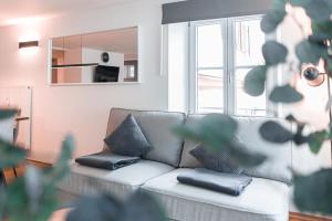 ディリンゲン・アン・デア・ドナウにあるMihalca City Apartment Dillingen 02のソファと鏡のあるリビングルーム