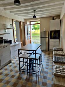 a kitchen with a table and some chairs in it at Gîte de la Coup'Neuve in Chemilli