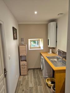 a kitchen with a sink and a washing machine at Gîte de la Coup'Neuve in Chemilli +6 photos