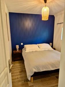 a blue bedroom with a bed and a blue wall at Gîte de la Coup'Neuve in Chemilli