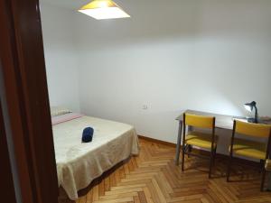 une chambre avec un lit, un bureau et deux chaises dans l'établissement Habitación de lujo, à Saint-Jacques-de-Compostelle