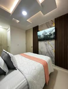 a bedroom with a bed with a painting on the wall at Refugio del Mar Barranquilla norte in Barranquilla +11 photos