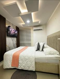 a bedroom with a large bed and a tv at Refugio del Mar Barranquilla norte in Barranquilla