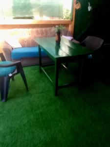 a table and a chair in a room with green grass at Casa de vacanță cu 4 camere Varlaam in Varlaam