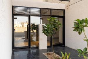 a glass door of a building with a plant at A beautiful one BR apartment with a living room in Al Madinah