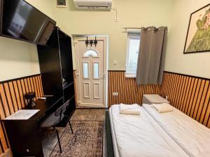 a room with a bed and a desk and a door at Cozy Modern Studio in Debrecen