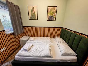 a small bedroom with two beds and a window at Cozy Modern Studio in Debrecen