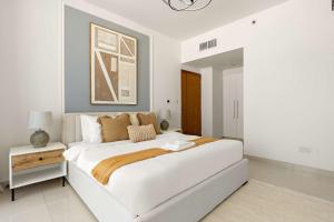 ein weißes Schlafzimmer mit einem großen Bett in einem Zimmer in der Unterkunft Silkhaus Executive 2BDR in Al Reem Island in Abu Dhabi + 15 Fotos