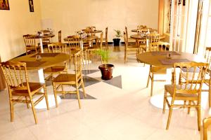 a dining room with wooden tables and chairs at Okura Hotel in Gulu