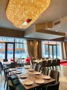a dining room with tables and chairs and a chandelier at New Gudauri Panorama View Loft II in Gudauri