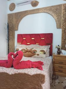 un lit avec deux serviettes rouges dessus dans l'établissement Riad Derb El Aarsa, à Marrakech