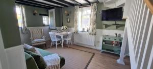 a living room with a couch and a table and a tv at Charming cottage in Pilton-newly renovated in Barnstaple