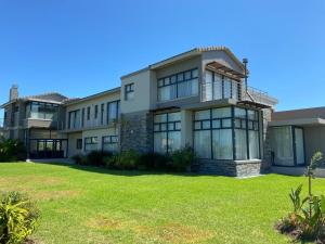 a large house with a lawn in front of it at Ocean Vista Luxury Oubaai in Herolds Bay