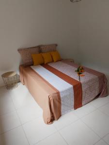 a bedroom with a large bed with yellow pillows at Villa Heliconia à 10 min des plages et des tortues in Les Anses-dʼArlets