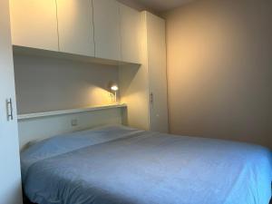 a bedroom with a bed and a white cabinet at App Zouavenplein 0403 in Koksijde