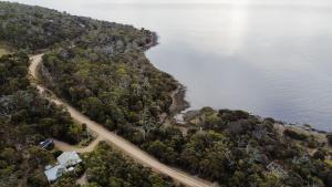 an aerial view of a road next to a lake at Mandala Bruny Island in Alonnah
