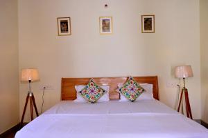 a bedroom with a white bed with two lamps at Jaipur Eco Village in Jaipur +61 photos