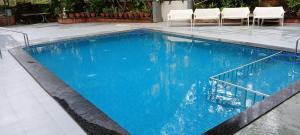 a large blue swimming pool with white chairs in it at Star Regency Resort & Spa in Lonavala