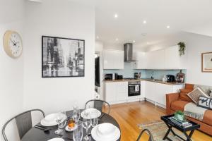 Una cocina y una sala de estar con mesa y sillas. en Sunny TopFloor 1BR , Balcony Views Sleeps 3, en Londres