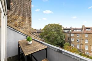 balcón con mesa y vistas a los edificios en Sunny TopFloor 1BR , Balcony Views Sleeps 3, en Londres