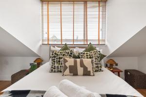 Un dormitorio con una cama grande con almohadas. en Sunny TopFloor 1BR , Balcony Views Sleeps 3, en Londres
