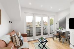 una sala de estar con un sofá y una mesa en Sunny TopFloor 1BR , Balcony Views Sleeps 3, en Londres