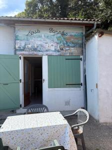 a table and chairs in front of a building at Petite maison au coeur des Hautes-Alpes in Aspres-sur-Buëch
