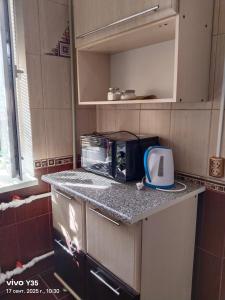 La cocina está equipada con tostadora y microondas. en На площади 2, en Kyzylorda