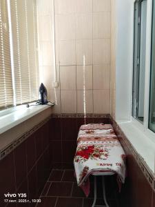 Habitación con banco en la esquina de un baño en На площади 2, en Kyzylorda
