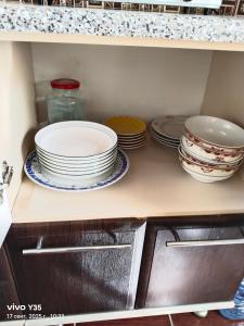 un estante con platos y tazones en una cocina en На площади 2, en Kyzylorda 4 fotos más