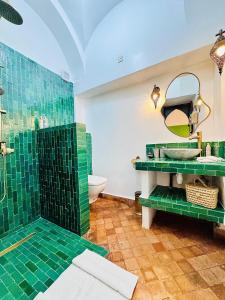 y baño con ducha de azulejos verdes y lavabo. en Riad Dar Beldia and Spa, en Marrakech