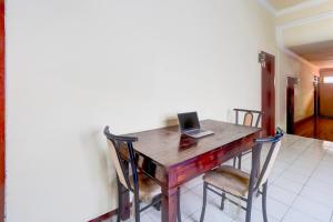 a wooden table with a laptop on top of it at OYO 94818 Sabina House Syariah in Blitar
