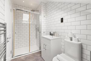 y baño blanco con ducha, aseo y lavamanos. en Sunny TopFloor 1BR , Balcony Views Sleeps 3, en Londres 21 fotos más