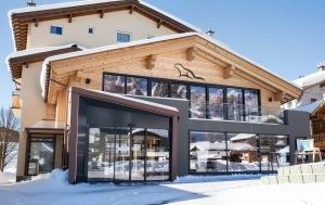 萨姆瑙恩Black Summit Samnaun Boutique Hotel的带有大型建筑的滑雪小屋