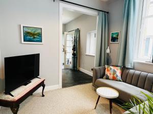 a living room with a couch and a flat screen tv at Dungora House in Crieff