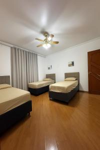 Zimmer mit 3 Betten und einem Deckenventilator in der Unterkunft Casa com 3 quartos e 1 suite - para 9 Pessoas in São Paulo + 30 Fotos