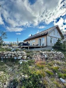 a house with a stone wall in front of it at Large lovely mountain house in Vemdalsskalet in Vemdalen +40 photos