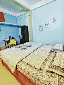 a large bed in a room with a table at Jonaki Abax Homestay in Nowgong