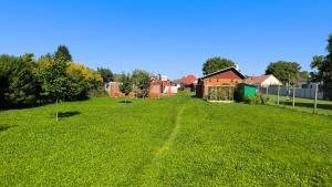 un campo de césped verde con casas en el fondo en Apartman Losonszky, en Veľký Meder
