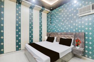 Un dormitorio con una cama y una pared azul. en Hotel O Saryu Ghat Formerly Balaji Palace, en Ayodhya